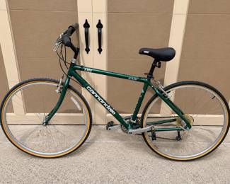 hu- This Cannondale H300 bike features a reliable 7-speed gear system, allowing for smooth and efficient riding across various terrains. It is equipped with a 42-inch frame size, ideally suited for comfortable handling and control. The bike sports a classic dark green color with sturdy steel construction designed for durability. The ergonomic design includes adjustable handlebars and a cushioned saddle to enhance rider comfort. Includes helmet.