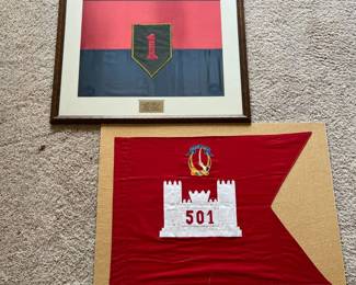 cd- The first is a framed red-and-blue textile display featuring the distinctive “Big Red One” 1st Infantry Division insignia. A mounted plaque identifies officer and documents his service as Secretary of the General Staff from June 8, 1987–July 7, 1988, and Assistant Chief of Staff from July 7–September 7, 1988, with the 1st Infantry Division (Mechanized). Also included is a red swallowtail-style military guidon/display featuring an appliquéd white castle with “501” and an embroidered “Garry Owen” crest above. Both pieces show age-related wear consistent with display and storage. The framed piece has visible discoloration/spotting to the mat and textile, while the red guidon shows wrinkles, creasing and some surface wear. See photos for condition and details. An interesting group with strong named military provenance and documented late-Cold War-era association with the 1st Infantry Division (Mechanized). Framed: 26.5in x 32in Not Framed: 27in x 36in