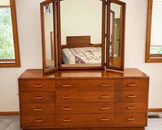 gl- This elegant wooden tri-fold dresser features a unique curved arched center panel in the mirror, adding a sophisticated touch to any bedroom. Crafted with a rich cherry finish, the dresser combines style and functionality with multiple drawers for ample storage. The dresser measures 30 inches tall, 66 inches wide, and 18 inches deep, while the mirror stands 42.5 inches tall and 51 inches wide. Made in the USA, this piece showcases quality craftsmanship and timeless design.