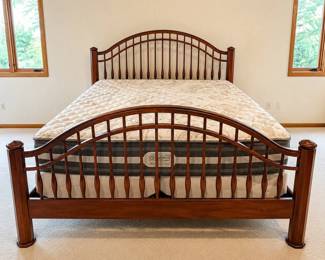 gr- This king size bed set features a sturdy wooden frame with elegantly curved headboard and footboard, standing 56.5 inches and 39.5 inches tall respectively. The set includes a comfortable Beautyrest mattress and matching box springs. The rich wood finish highlights the detailed craftsmanship, adding a classic touch to any bedroom décor. The bed offers ample support and style, perfect for those seeking both function and aesthetic appeal.