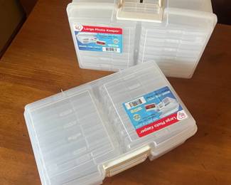 lu- This large photo keeper is designed to securely store and organize a wide variety of photos and small items. Made from durable transparent plastic, it allows easy visibility of contents without opening. The keeper features multiple removable storage compartments inside, providing customizable organization options. It includes a sturdy white handle for convenient portability, and a secure latch to keep items safely enclosed. Its compact yet spacious design makes it perfect for photographers, scrapbookers, or anyone looking to protect and arrange their photo collection effectively.