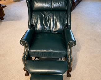 gv- This elegant dark green leather recliner chair features a classic design with rolled arms and detailed nailhead trim. Measuring 42 inches tall, 30 inches wide, and 34 inches deep when not reclined , this chair provides comfortable seating with an extendable footrest for added relaxation. Crafted from high-quality leather, the chair combines durability with timeless style, making it a perfect addition to any living room or study.