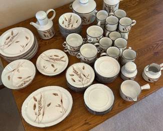 ev- This vintage Stonehenge Oven-To-Tableware set, named "Midwinter," by the Wedgwood Group England features a comprehensive collection of ceramic dining pieces including plates, cups, pitchers, and serving pots. The set is distinguished by its speckled off-white base color adorned with delicate brown botanical illustrations, capturing a rustic and vintage aesthetic. Designed for oven-to-table use, the durable ceramic material combines functionality with elegant country-style charm. Ideal for collectors or those appreciating classic English pottery, the set highlights the artisanal craftsmanship and timeless design unique to Wedgwood's Midwinter line.