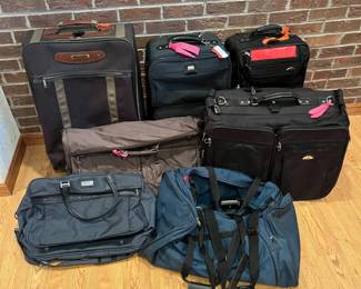ip- This diverse collection features eight pieces of travel luggage and bags, each with unique carrying options including wheeled suitcases, garment bags, duffel bags, and briefcases. Highlighting various colors such as black, brown, dark blue, and tan, the set showcases a mix of materials designed for durability and functionality. Key details include multiple zippered compartments, sturdy handles, and some items with brightly colored tags for easy identification, perfect for versatile travel needs. Brown Suitcase: L: 18in W: 9in H: 28in Vertical Black Suitcases: L: 14in W: 9in H: 24in Horizontal Black Suitcase: L: 22in W: 9in H: 20in Brown Garment Bag: 41in x 22in Blue Duffle Bags: Large- L: 37in W: 18in H: 12in, Small- L: 15in W: 10in H: 10in Grey Duffle Bag L: 20in W: 8in H: 12in