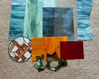mi- This collection features an assortment of 14 stained glass pieces showcasing a variety of swirling colors including shades of green, blue, orange, and red. The set includes several large sheets of glass with fluid, marbled patterns in green and blue hues, smaller solid orange and deep red panels, and intricate decorative elements shaped like wreaths and bells in green tones. There's also a beautifully crafted round panel with a white background and red geometric accents. Pieces vary in size and shape, suitable for detailed craft projects or custom stained glass work, all made from high-quality translucent glass that captures and diffuses light beautifully. Green Glass: 24.3in x 17.7in Dark Blue Glass: 19.7in x 17in Blue Glass: Large Piece- about 25.5in x 17in, Medium Piece- about 14in x 9in, Small Piece- about 11.5in x 8in 2 Clear Pieces: 24in x 18in 2 Orange Pieces: 12.3in x 12.3in Red Glass: 12in x 9.3in Circular Piece: 13.3in