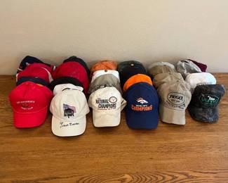 mf- This diverse assortment of 33 baseball caps features a variety of sports teams, brands, and commemorative designs. Highlights include Denver Broncos Super Bowl Champions caps in bold orange, blue, and grey tones, Texas Longhorns themed caps in white, orange, and camo patterns, and several branded hats such as Cabela’s, Jaeger, and Lone Star veteran commemorative caps. The caps vary in colors including red, white, black, navy, olive green, and camouflage, showcasing a mix of cotton and durable fabric materials. Many caps are adjustable with catch straps and buckles, suitable for a range of head sizes. Perfect for collectors or sports enthusiasts looking to display or wear memorabilia from different teams and special events.