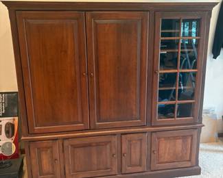 hi- This elegant entertainment center is crafted from traditional cherry wood, showcasing a rich, warm finish that enhances any living space. Measuring 69 inches tall, 72 inches wide, and 27 inches deep, it offers ample storage with multiple drawers, cabinets, and glass-paneled doors for display. The design features open shelving, spacious compartments, and a pull-out platform, perfect for organizing media devices and accessories. Its classic style and durable wooden construction make it a timeless addition to your home.