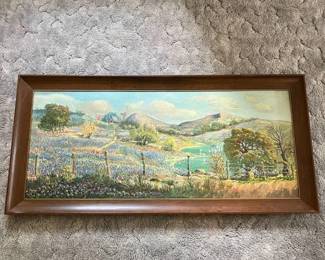 ee- Original oil landscape painting depicting a colorful rural scene with rolling hills, a winding creek, fence line, trees, distant buildings, and fields of blue and purple wildflowers. The painting features prominent hand-applied brushwork and areas of heavy impasto, particularly throughout the foreground flowers and vegetation. Signed and dated in the lower left “L. Barbee 57,” indicating a likely 1957 date. Presented in a wide wood frame with gold-tone inner trim. The painting and frame show age-appropriate wear consistent with a vintage work. Please review photographs for condition.