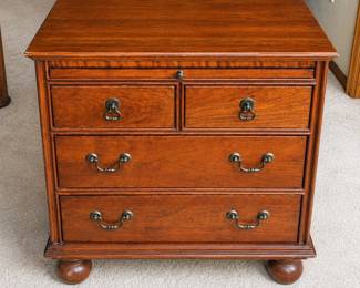 gq- This Lexington Carolina Night Chest is a beautifully crafted wooden nightstand featuring a rich, warm brown finish and traditional design elements. It includes four drawers with antique-style metal handles, offering ample storage space. The nightstand measures 27 inches tall, 26 inches wide, and 18 inches deep, making it compact yet functional for any bedroom. Constructed in the USA, this piece stands on sturdy rounded feet and combines classic elegance with practical storage.