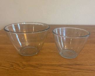 jw- This set includes two clear glass bowls, one larger and one smaller, perfect for various kitchen uses. The larger bowl measures approximately 8 inches in diameter and 5.5 inches in height, while the smaller bowl measures about 6.5 inches in diameter and 4.5 inches in height. Made from transparent glass, these bowls offer a classic and versatile design suitable for mixing, serving, and food prep.
