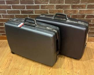 io- This vintage American Tourister suitcase set features two sturdy hard shell cases in classic black, designed for durability and style. Each case includes a secure combination lock and key lock mechanism for added security. The interiors are lined with a light-colored fabric, providing ample space and organizational pockets for documents and essentials. The suitcases are medium-sized, making them ideal for business travel or daily professional use. The textured black exterior offers a timeless, professional look while being resistant to wear and scratches. L: 26in W: 8in H: 20in