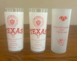 ki- This set includes three vintage University of Texas collector pint glasses featuring classic designs in orange. Two glasses display detailed portraits of notable figures associated with the university, while the third showcases the university logo along with iconic Longhorn imagery. Crafted from frosted and clear glass, these glasses stand approximately 7 and a half inches tall with a diameter near 2.5 inches, making them perfect for collectors and alumni alike. The distinctive orange print highlights the university's heritage and spirit, offering a unique and nostalgic addition to any collection.