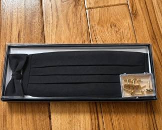 cf- U.S. Army formal mess dress accessory collection featuring a black pleated adjustable cummerbund and matching bow tie, presented in a fitted storage box. Also includes an assortment of gold-tone cufflinks, shirt studs and related formalwear accessories in a small clear case. Cufflinks include a pair featuring the U.S. Army Corps of Engineers castle insignia as well as a pair decorated with a U.S. eagle emblem surrounded by four stars. Includes original box.