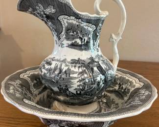 la- This exquisite antique wash set features a matching basin and pitcher adorned with intricate black and white transferware scenes depicting pastoral and architectural elements. The ceramic pieces showcase finely detailed floral borders and classic 19th-century style motifs. The basin measures approximately 12 inches in diameter, highlighting its generous size and decorative appeal. Crafted from durable ceramic with a glossy finish, this wash set is both functional and collectible, adding vintage charm to any decor.