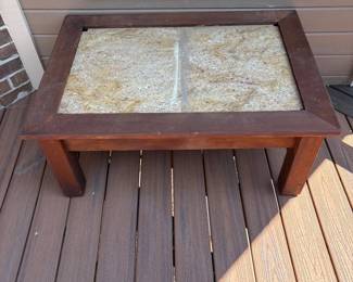 he- This rectangular coffee table features a sturdy wooden frame with a rich, dark finish and a top surface composed of two large travertine tiles that can be interchangeable with other types of large tiles.The table measures 18 inches tall, 41 inches wide, and 29 inches deep, offering ample space for decor or functional use. The combination of natural travertine tiles and solid wood gives it a classic, elegant look ideal for both indoor and outdoor settings.