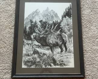 da- This framed black and white wildlife print depicts a majestic elk with large antlers standing in a forest clearing with additional elk and towering mountain peaks in the background. The artwork showcases detailed stippling technique and is signed by the artist Bill O'Neill. It is mounted with a neutral-toned matte and enclosed in a textured dark wood frame with a protective glass cover. The back features a secure hanging mechanism and a label indicating the framing was professionally done. The monochromatic color scheme along with the intricate natural scenery makes this piece a striking addition for any nature or wildlife art enthusiast.