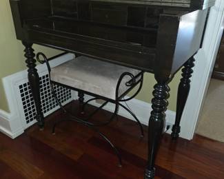 This vintage dark wood spinet desk features distinctive turned bobbin-spindle legs and a fold-out writing surface.