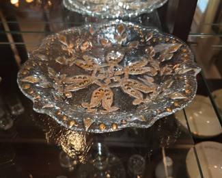 vintage decorative glass plate features a textured, iridescent finish with a raised metallic gold floral and leaf medallion pattern.