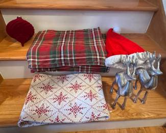 Assorted Christmas Decor Lot: Plaid Throws, Snowflake Blanket, Santa Hat, Reindeer Figurines, and Onion Ornament
