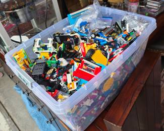 LEGO pieces, along with some partially built vehicles and structures.