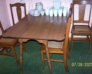 Drop leaf kitchen table, five cane bottom chairs