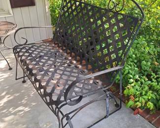Wrought iron glider, one of several pieces of wrought iron outdoor patio furniture