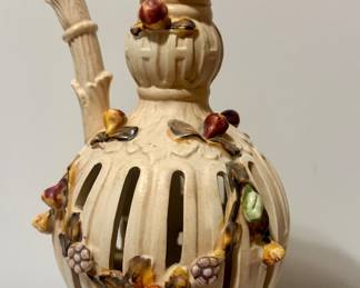 Ornate vintage openwork ceramic ewer/pitcher with a dramatic scrolling handle, pierced body, raised floral details, and charming hand-painted snail, bird, and insect accents,