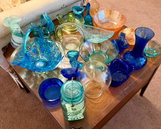 Beautiful collection of colorful vintage glassware in cobalt blue, aqua, teal, green, and pink. Includes baskets, bowls, vases, serving dishes, candlesticks, and unique decorative pieces—many with molded and pressed-glass patterns.