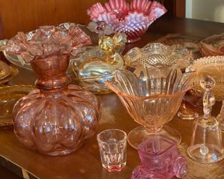 Fenton and vintage Depression glass, including a Fenton cranberry pink opalescent hobnail ruffled bowl, pink Depression glass candy compote dish, and a vintage Fenton Melon Optic cranberry vase with ruffled rim. Also includes additional pink, amber, and clear pressed-glass serving pieces, covered dishes, and decorative glassware.