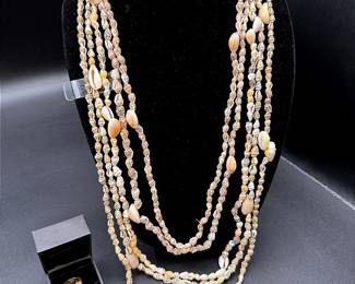 A Pink Stone Ring In A Gold-toned Setting And Five Shell Necklaces