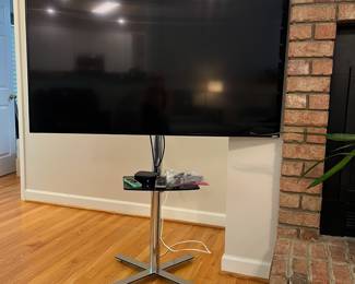 H24 - $120. 55” Vizio TV Model M55-C2 on Chrome Stand. TV on Stand Measures 59.5” Tall.
