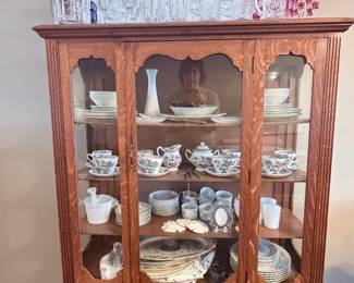 Beautiful vintage oak china cabinet filled with assorted china, serving pieces, and sparkling glassware a treasure trove for collectors and entertainers! ✨
