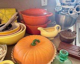 Kitchen favorites include a KitchenAid stand mixer with attachments, colorful nesting bowls, an orange enameled Dutch oven, and a festive pumpkin-shaped covered serving dish! 🎃🍳✨