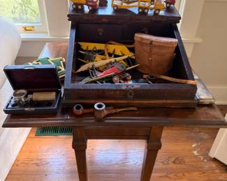 Antique writing table with estate pipes and vintage toys
