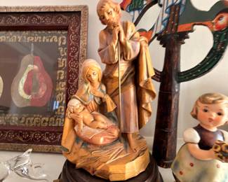 Carved wood nativity figurine and Hummel figurine