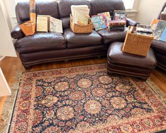 Brown leather sofa and ottoman with Oriental rug