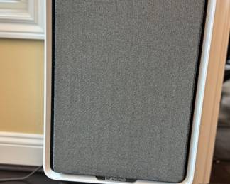 BISSELL air purifier with a modern fabric-front design and wood-look legs.