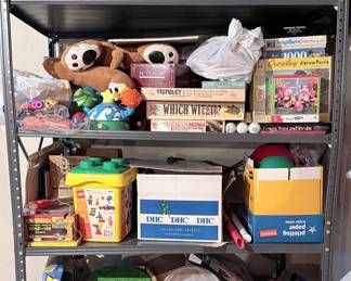 Assorted Vintage Board Games and Collectible Toys Collection on Metal Shelving Unit