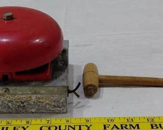 Antique red boxing or wrestling bell on wooden platform stand with wooden mallet. 