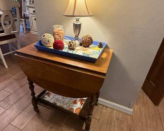 wooden drop-leaf side table with turned legs and lower display shelf