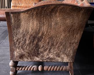 Spanish Colonial Style Leather Upholstered Sofa with Heavily Distresses Patinated Leather Seat, Turned Wood Frame with Hair on Hide Surround. Measures 80" W x 40" D. Photo 3 of  4. 