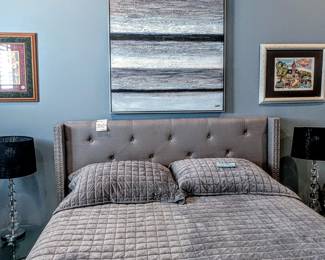 Gray tufted queen bed, artwork