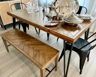 slatted wood table and bench, 3 black metal chairs, silver serving items
