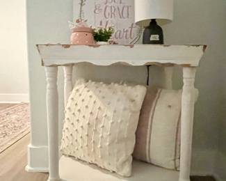 white side table, throw pillows, lamps, art work