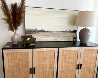 black and ratan cabinet, lamp, and canvas print