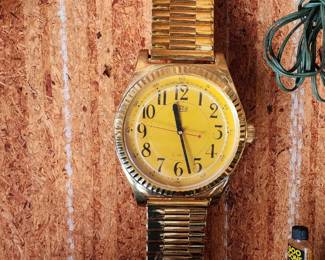  Large gold wristwatch repurposed as a wall-mounted clock