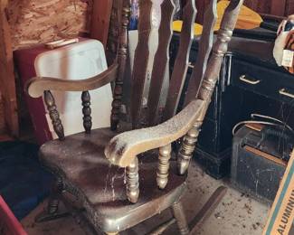 Stored away old large rocking chair in barn.