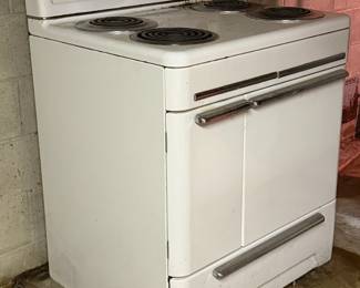 Vintage Monarch Electric Range / Stove Vintage Monarch electric range with white porcelain/enamel finish, chrome accents, four coil burners and original Art Deco-style Monarch controls and hardware. Original Monarch identification plate remains inside the lower compartment. Wonderful vintage kitchen appliance with great period character. Shows age-related wear and surface soiling from storage. Untested; working condition unknown. Buyer responsible for removal.