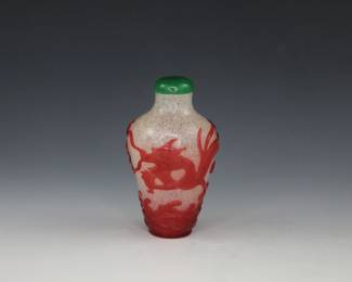 Snowflake glass with red overlay depicting a dragon flying over waves