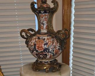 PAIR of 19th-century Japanese Imari porcelain vases featuring intricate hand-painted floral and bird motifs accented with French ormolu (gilt-bronze) rococo mounts displayed on oynx/alabaster pedestals